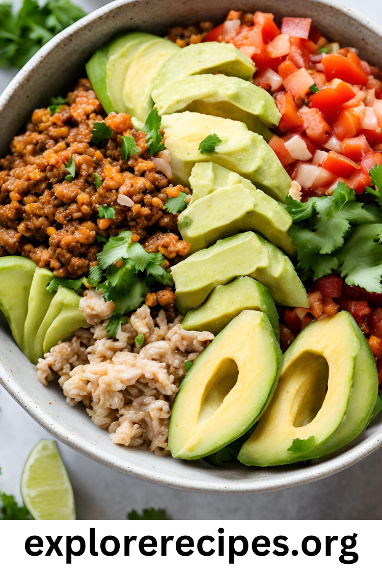 A colorful turkey taco bowl filled with lean ground turkey, brown rice, black beans, fresh tomatoes, bell peppers, avocado slices, and topped with Greek yogurt and cilantro.